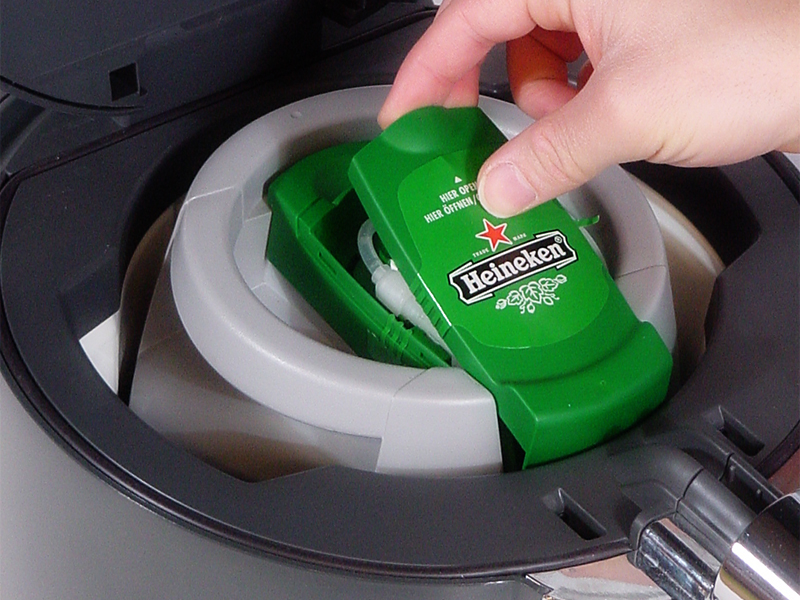 Green Heineken Beertender cartridge being placed into the appliance